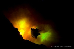 Diver enters a cave system where the clear spring water m... by Becky Kagan 